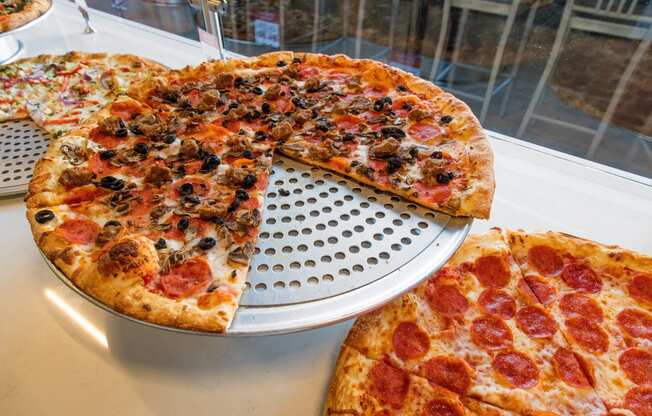 a pepperoni pizza with a slice cut out of it on a pizza pan