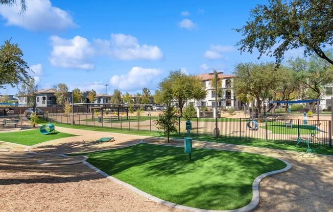 a dog park with a green grassy area and a playground
