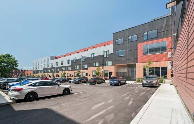 A parking lot with cars and a building in the background.