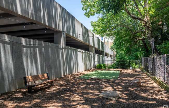 a bench sits in the shade under a building