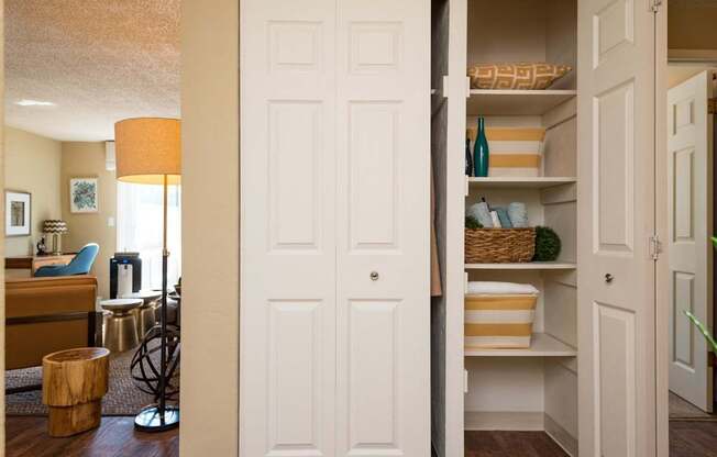 A white door is open to a hallway with a basket on the shelf.