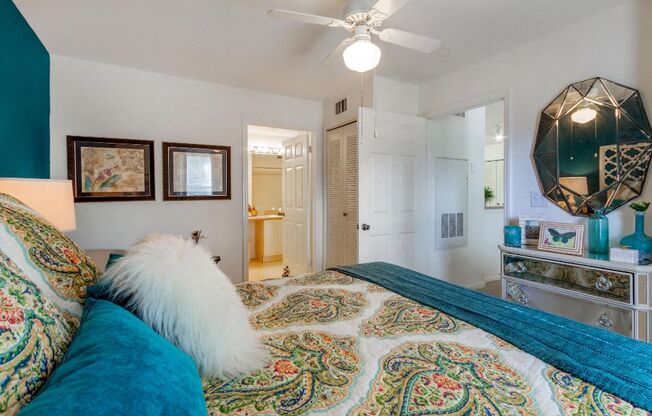 Bedroom with accent wall, decorative pillows and bedding, and dresser