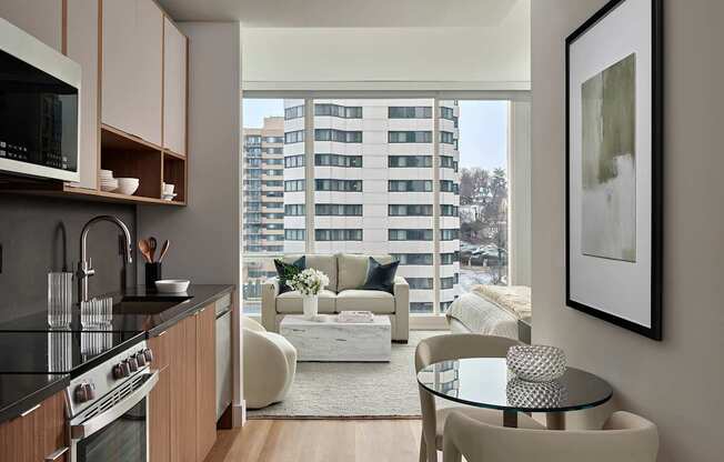 A modern kitchen with a view of a balcony with a white couch and a table.