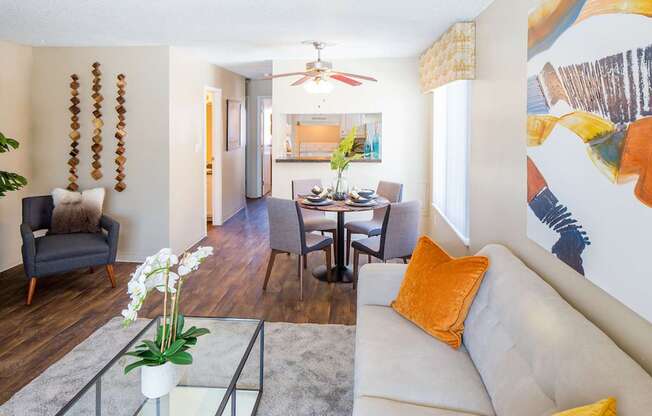 A living room with a white couch and a glass coffee table.