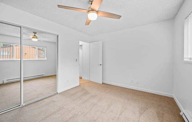 a bedroom with a ceiling fan and a mirror
