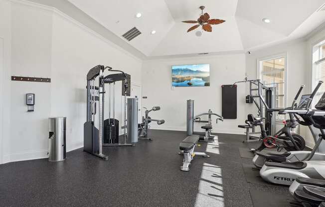 A spacious gym with a variety of equipment including treadmills, stationary bikes, and weight machines.