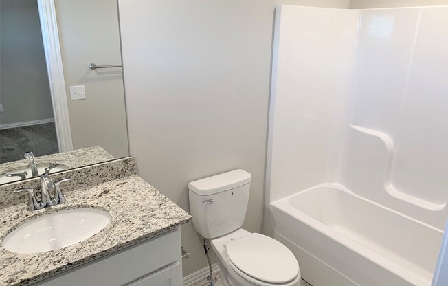 B2 (2-car) Guest Bath with granite countertops, sink, toilet, and shower