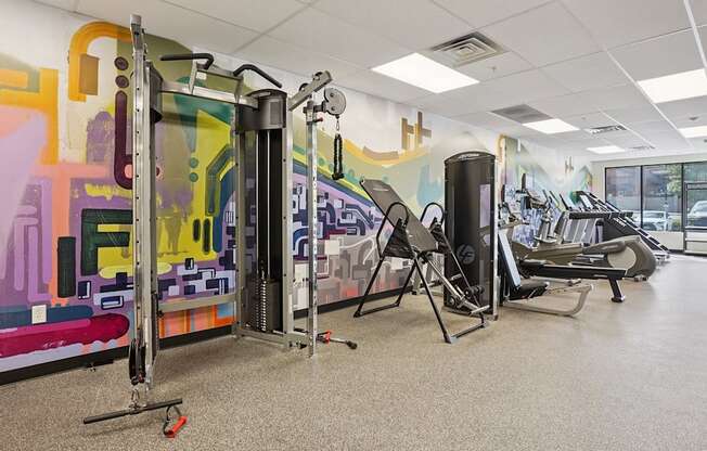 A gym with a row of treadmills and a row of stationary bikes.