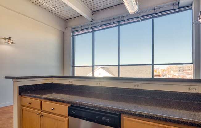 an empty kitchen with a large window and a counter top
