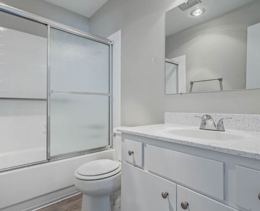 a white bathroom with a toilet and a sink at The Arches Apartments, El Cajon