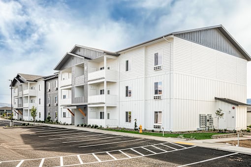 a white building with a parking lot in front of it at Gateway Apartments, East Wenatchee , WA