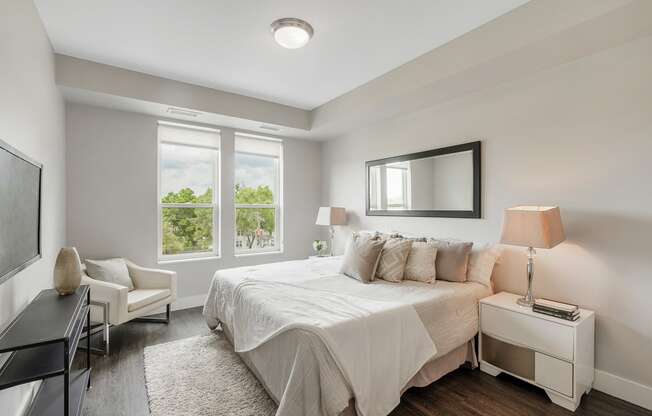 a white bedroom with a bed and a tv at Barrington 101, Illinois