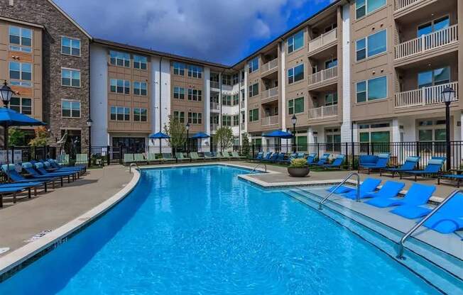 A large swimming pool in front of apartment buildings.