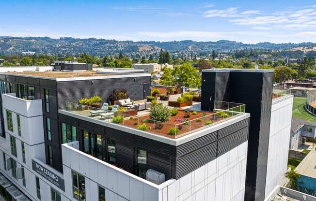 a building with a green roof with plants on top of it
