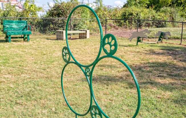 a green metal sculpture shaped like a flower in a park