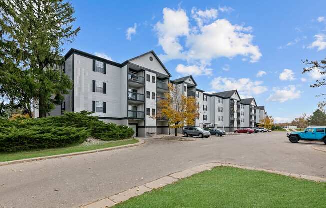Apartment complex with a blue car parked in front.