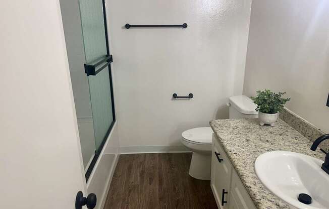 A bathroom with a toilet, sink, and shower.