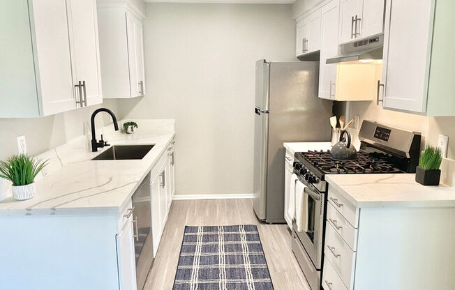 a kitchen with white cabinets and a stainless steel refrigerator at BLVD Apartments LLC, California