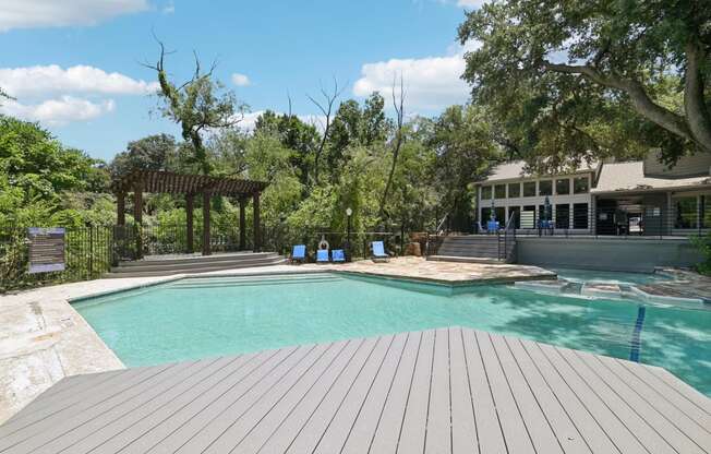 a swimming pool with a pool house in the background