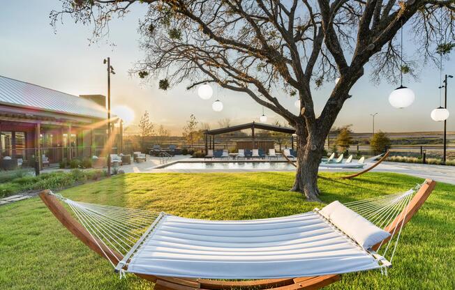 Serene poolside greens at Modera McKinney Ridge invite effortless relaxation, complete with hammocks and warm Texas sunsets.