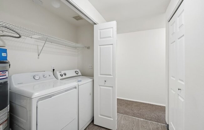 a white laundry room with white appliances and a white door