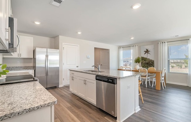 a kitchen with a large island and stainless steel appliances