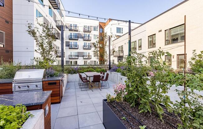 a patio with a grill and a table and chairs