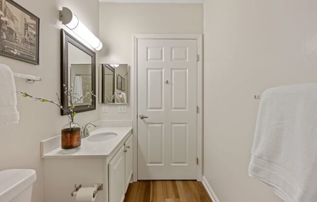 a bathroom with a white sink and toilet next to a white door