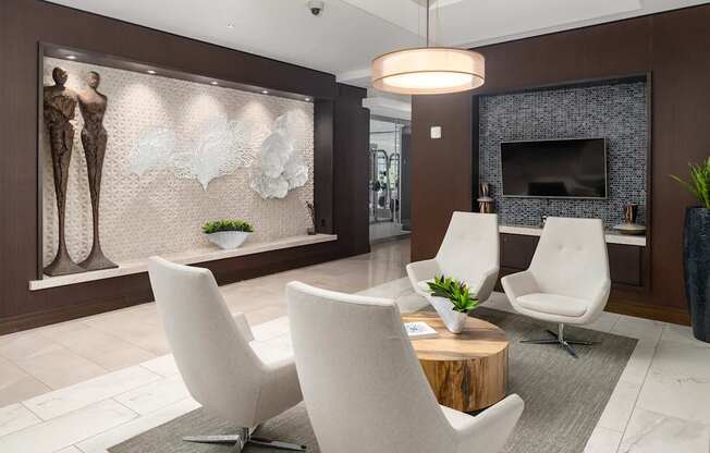 A modern living room with white chairs and a wooden coffee table.