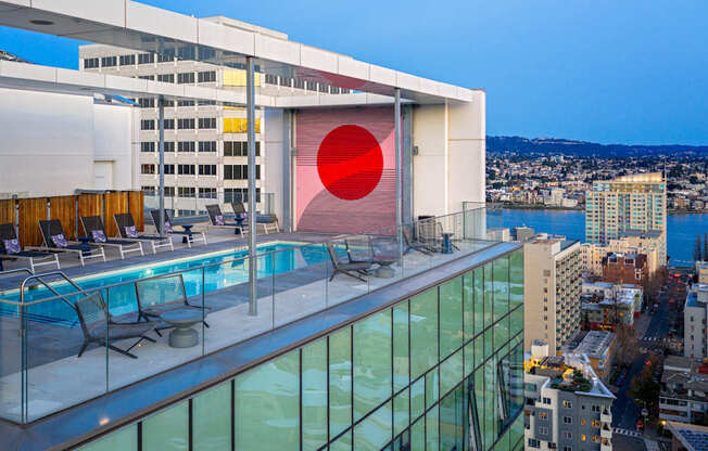 A modern building with a pool and a red circle on the side.
