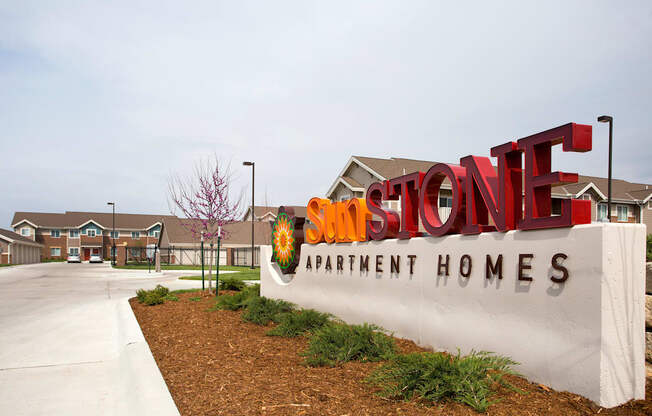 A sign for Stone Apartment Homes is displayed in front of a building.