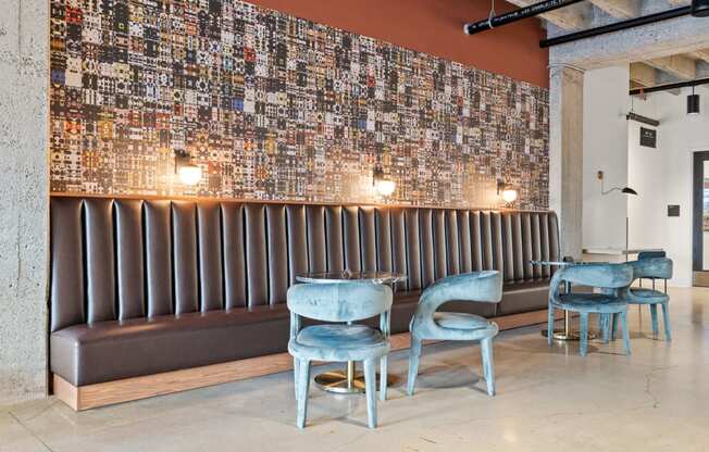 a seating area with blue chairs and a wall covered in graffiti