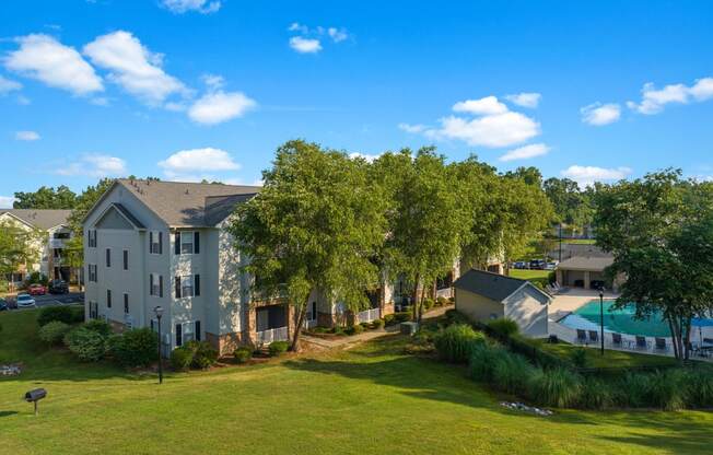 an aerial view of an apartment complex with green grass and trees