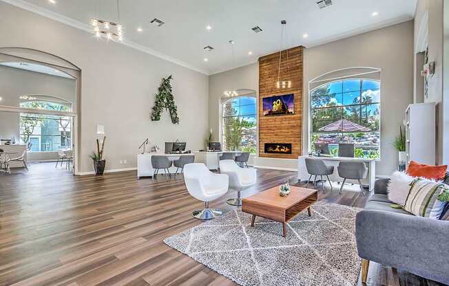 A living room with a grey couch, a wooden coffee table, and a TV mounted on the wall.