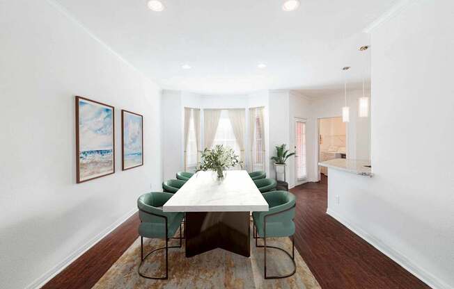 a dining room with a table and green chairs