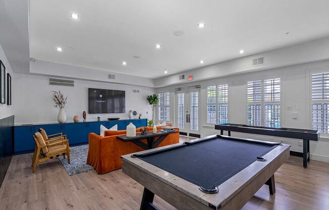 a game room with a pool table and a television