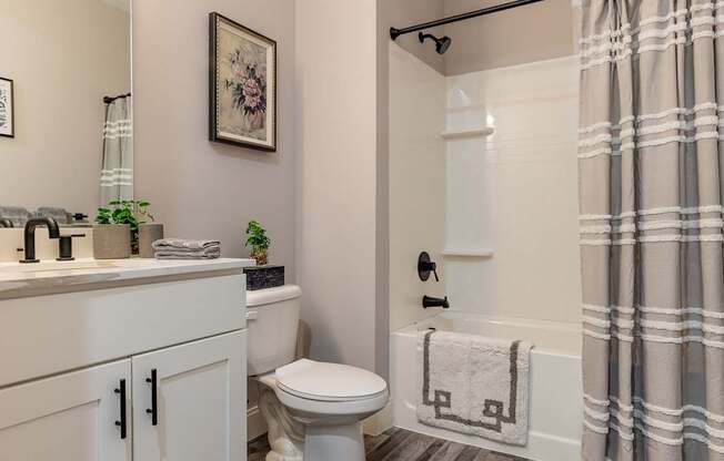 A bathroom with a toilet, sink, and shower.