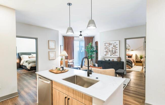 Open-concept kitchen and living area with access to dual bedrooms, warm finishes, and wood-style flooring throughout.