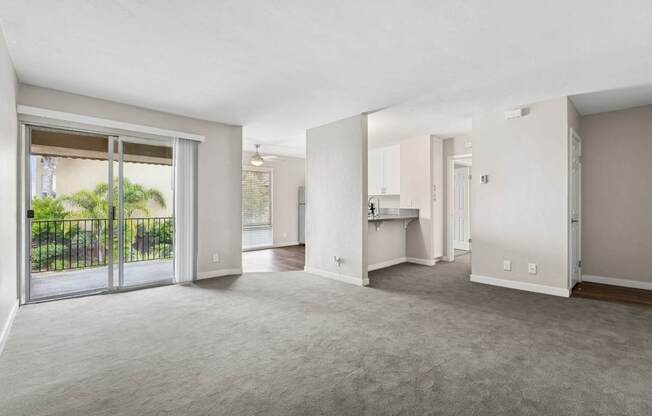 A spacious living room with a sliding glass door leading to a backyard.