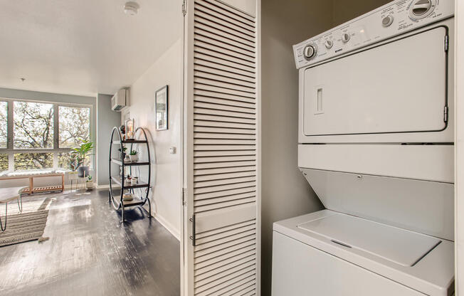 a laundry room with a washer and dryer and a living room with