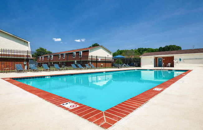 A large swimming pool with a red border and a white sign on the side.