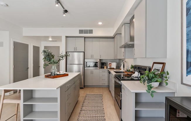 a kitchen with white counters and stainless steel appliances