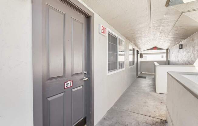 A grey door with the number 211 on it is closed.
