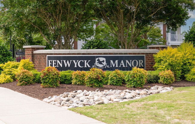 brick monement sign with Fenwyck Manor name and logo in front of community entrance