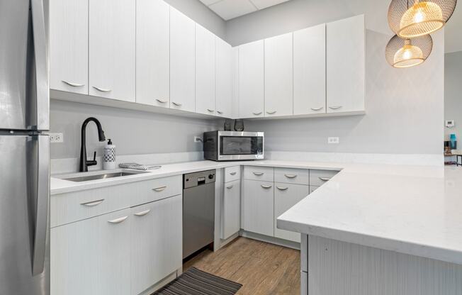 a kitchen with white cabinets and a stainless steel dishwasher
