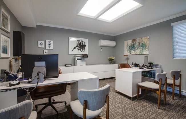 A modern office space with a skylight, desks, and chairs.