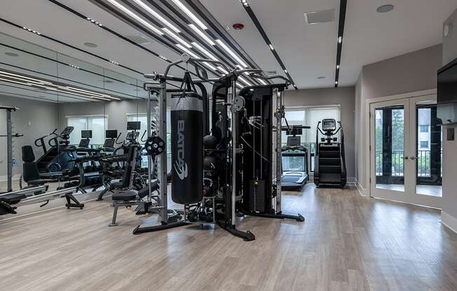 a gym with cardio machines and weights on a wooden floor