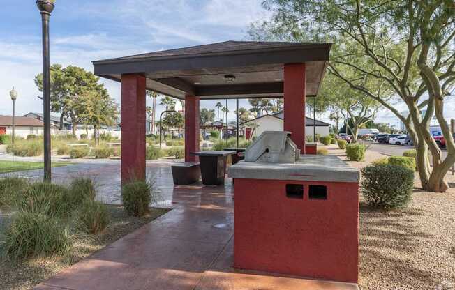 A red kiosk with a black trash bin and a black lamp post.