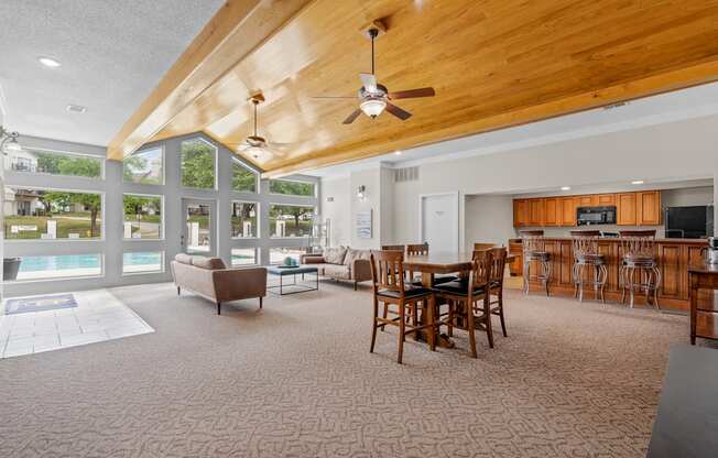 a large living room with a vaulted ceiling and large windowsat Millcreek Woods Apartments, Olathe, KS