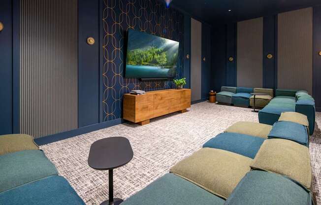 A room with a television and a row of couches.